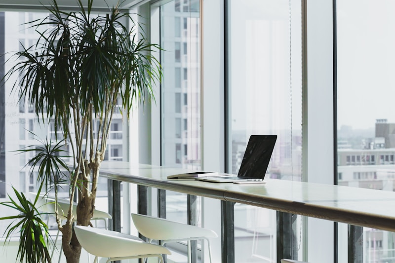 Neat desk with notebook resting beside a laptop during a pause